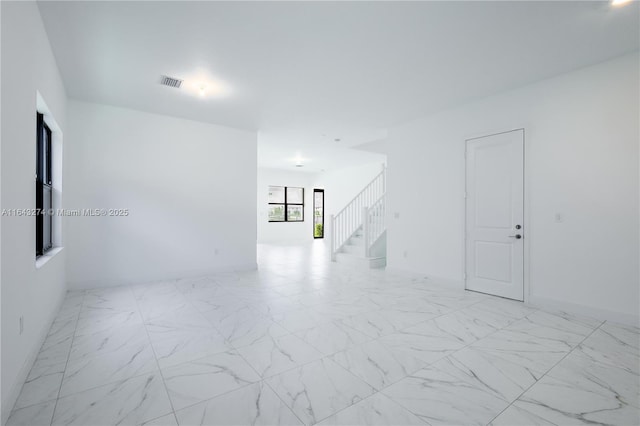 unfurnished room with stairs, marble finish floor, and visible vents