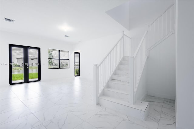 staircase with marble finish floor, visible vents, and french doors