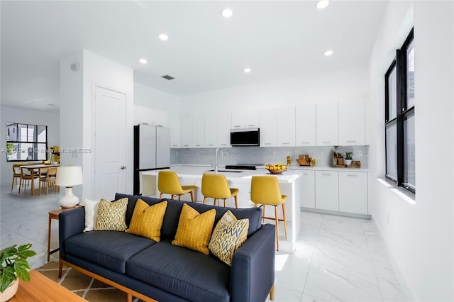 living room with recessed lighting, marble finish floor, visible vents, and baseboards