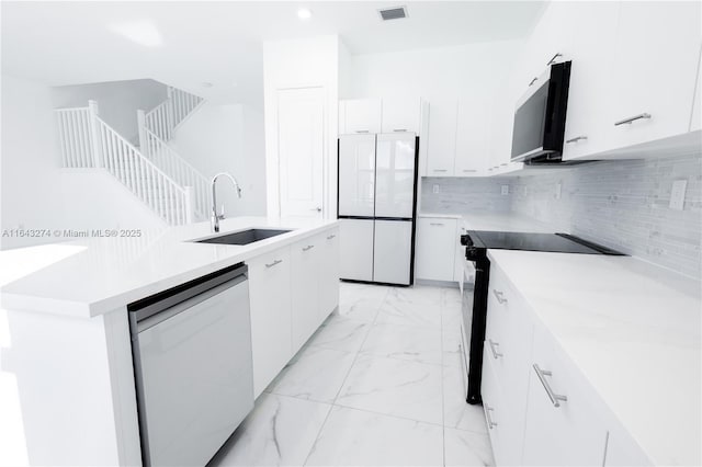 kitchen with marble finish floor, visible vents, white cabinets, a sink, and black appliances