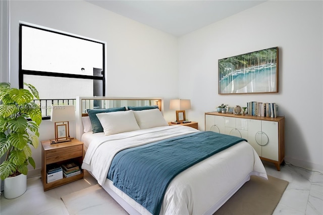 bedroom featuring marble finish floor and baseboards