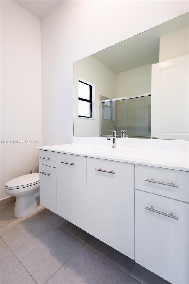 full bathroom featuring toilet, a shower stall, vanity, and tile patterned floors