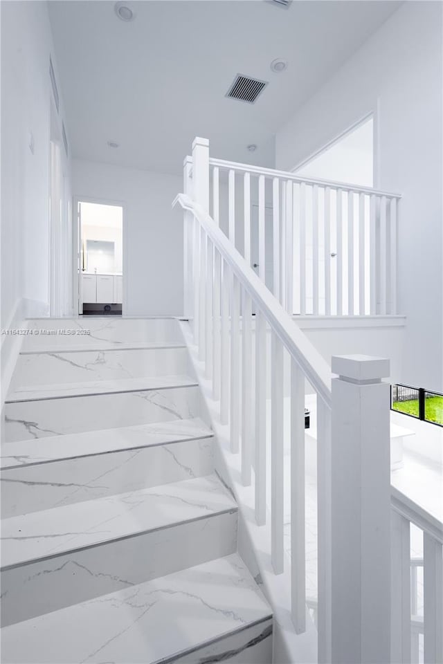 stairway featuring marble finish floor and visible vents