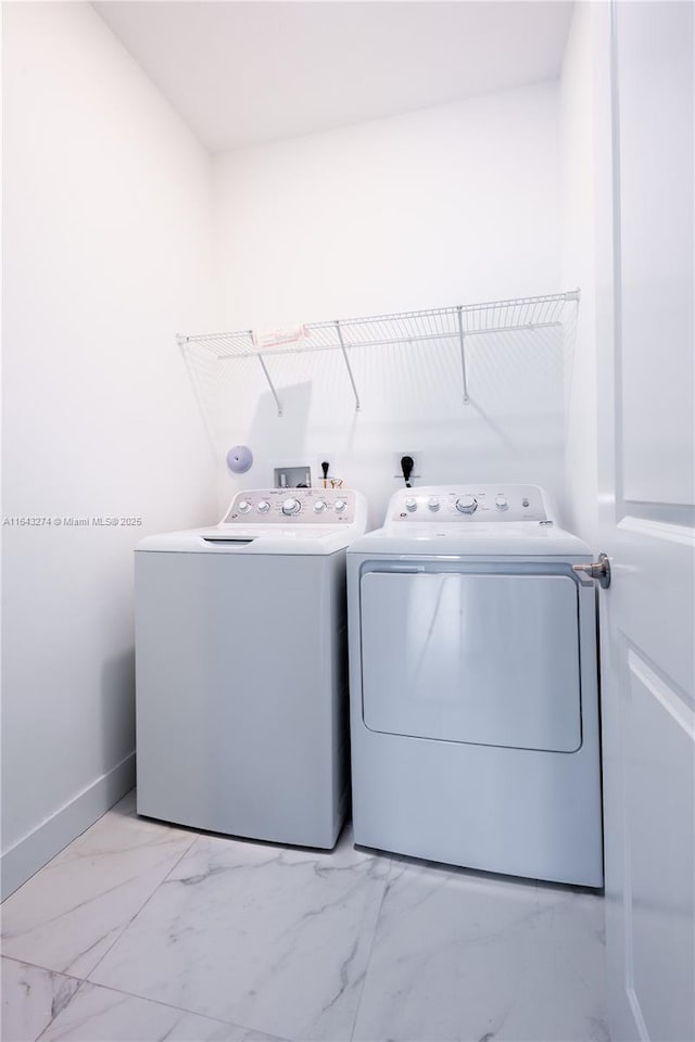 washroom with laundry area, baseboards, marble finish floor, and washer and dryer