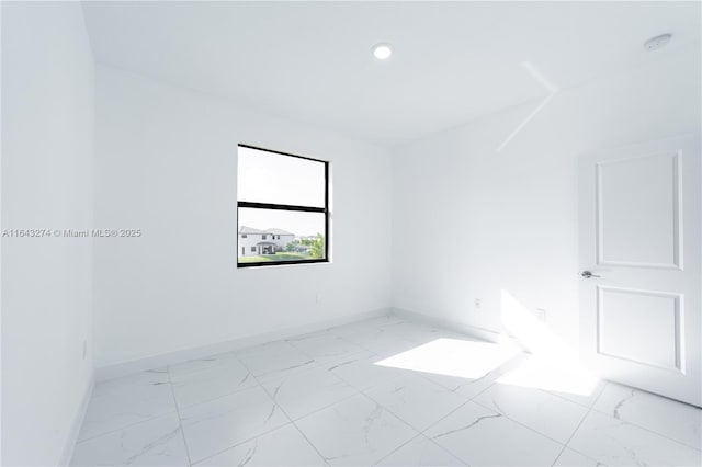 spare room with marble finish floor, baseboards, and recessed lighting