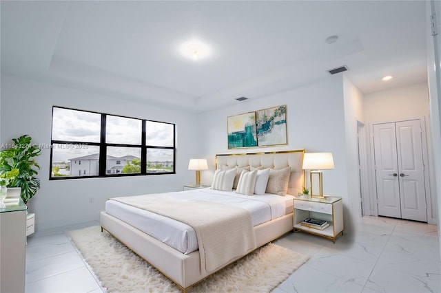 bedroom with marble finish floor, visible vents, and a raised ceiling