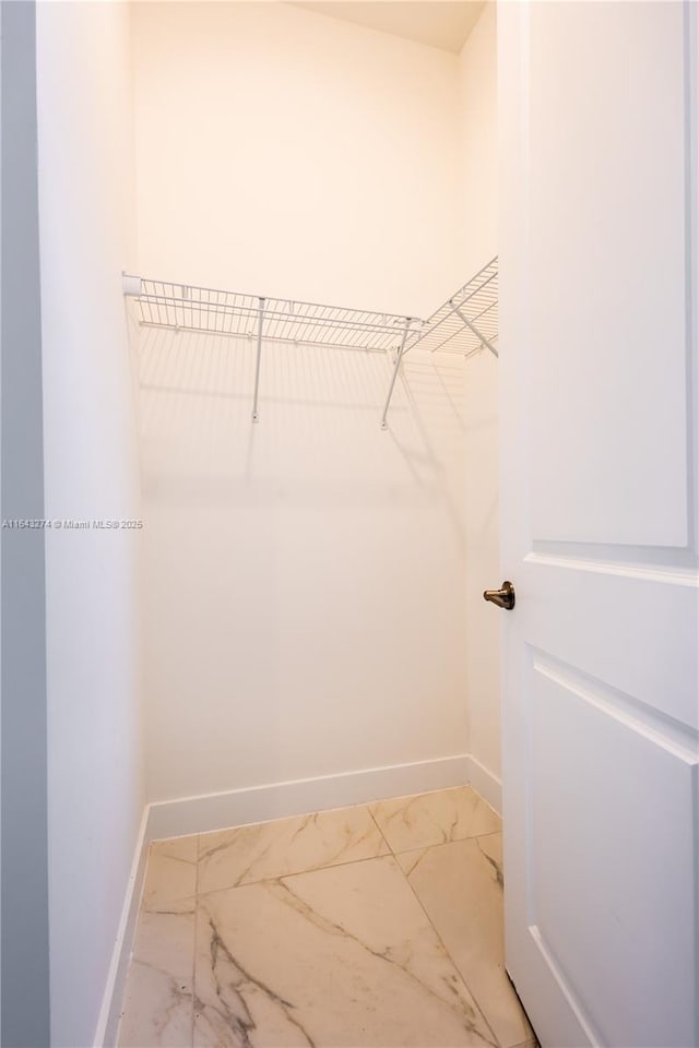 spacious closet featuring marble finish floor