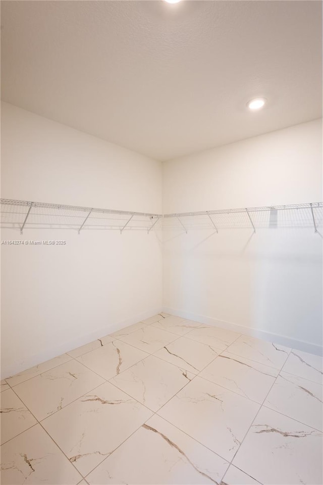 walk in closet with marble finish floor