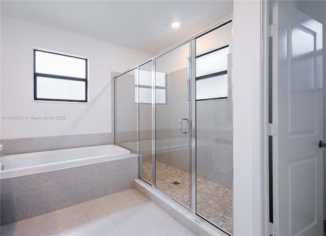 full bathroom featuring a stall shower, a wealth of natural light, a bath, and tile patterned floors