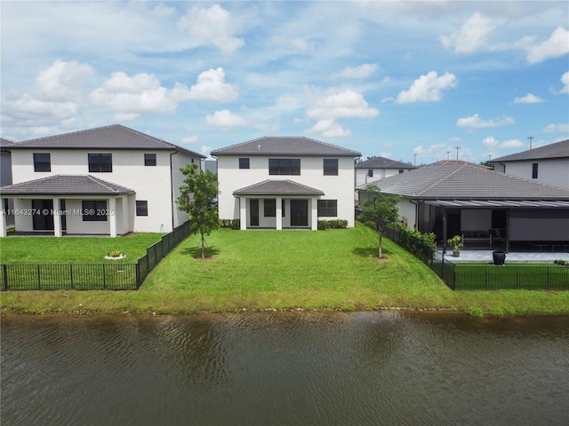 rear view of property with a yard, a water view, a fenced backyard, and a gazebo