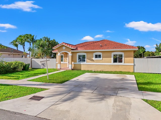 mediterranean / spanish home with a front lawn