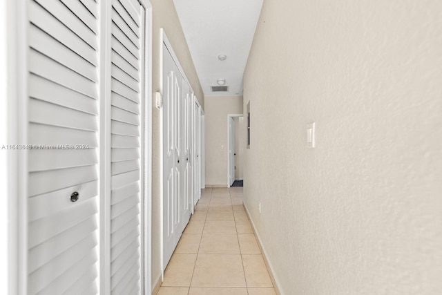 hall featuring light tile patterned floors