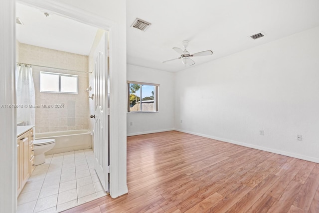 interior space with vanity, a healthy amount of sunlight, toilet, and ceiling fan