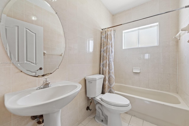 full bathroom featuring sink, tile patterned flooring, toilet, shower / bathtub combination with curtain, and tile walls