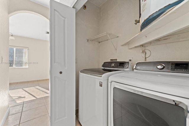 laundry area featuring washing machine and dryer and light tile patterned flooring