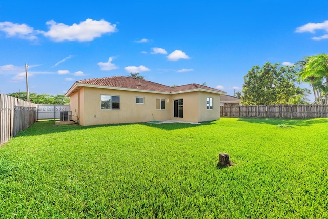 back of house featuring a lawn and cooling unit