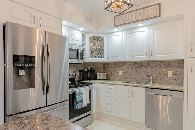 kitchen with backsplash, white cabinetry, light stone countertops, sink, and stainless steel appliances