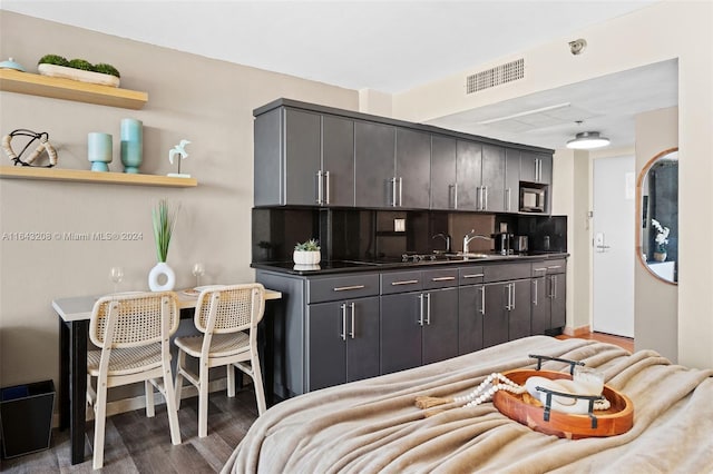 kitchen with backsplash, dark hardwood / wood-style flooring, and stainless steel microwave