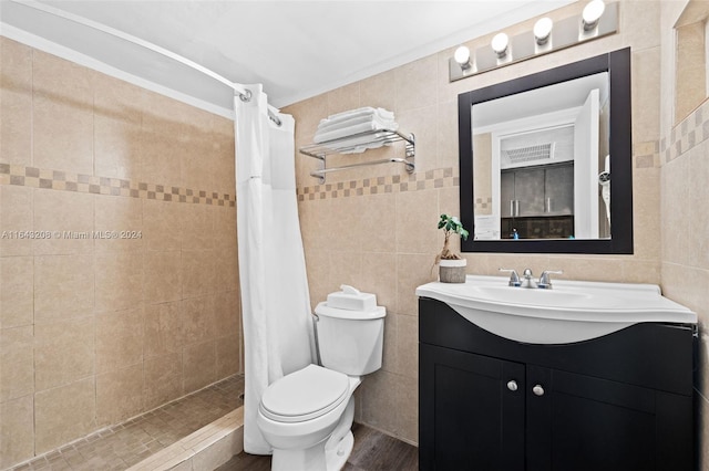 bathroom featuring toilet, walk in shower, vanity, and tile walls