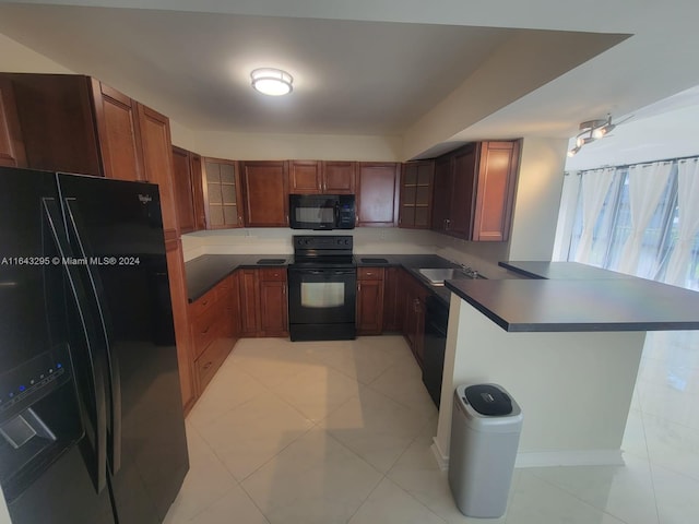 kitchen with light tile patterned floors, sink, kitchen peninsula, and black appliances