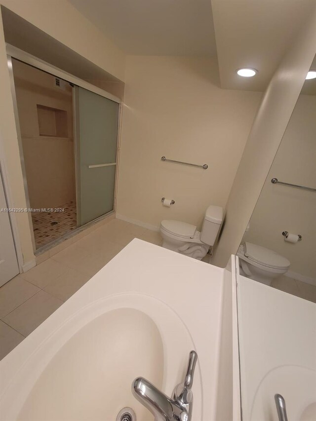 bathroom with tile patterned floors, toilet, and walk in shower