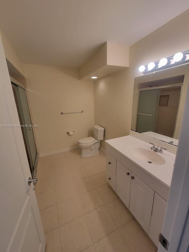 bathroom with tile patterned floors, toilet, vanity, and walk in shower