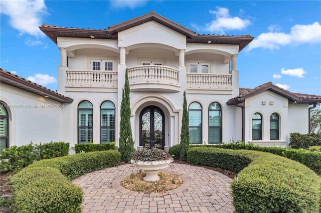 mediterranean / spanish-style house with a balcony and french doors