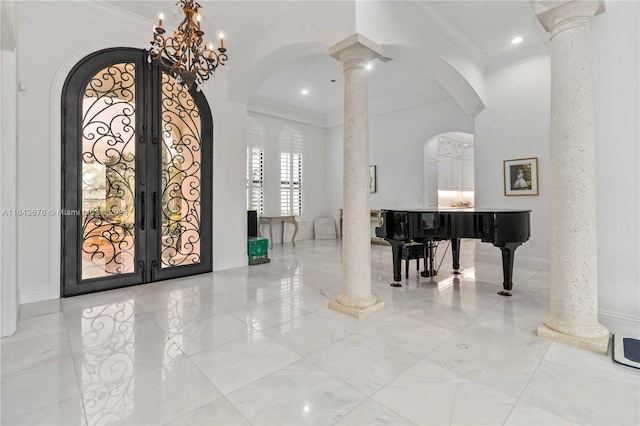 entrance foyer featuring ornamental molding, french doors, an inviting chandelier, and decorative columns