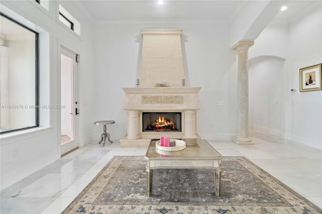 living room featuring crown molding, a high end fireplace, and ornate columns