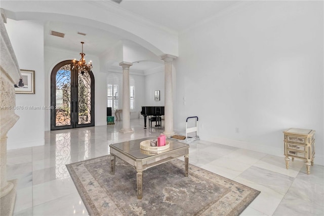 living room with decorative columns, crown molding, a notable chandelier, and french doors