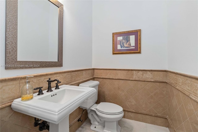 bathroom featuring tile walls, toilet, and tile patterned floors