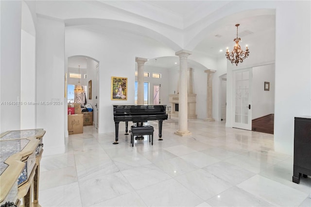 foyer with an inviting chandelier and ornate columns