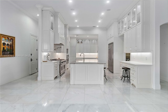 kitchen featuring high end appliances, sink, and white cabinets