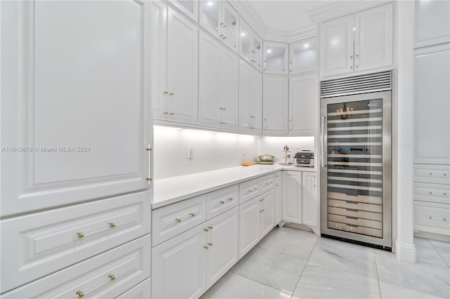 kitchen featuring beverage cooler and white cabinets