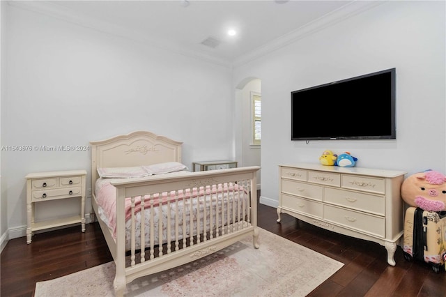 bedroom with dark hardwood / wood-style floors and crown molding