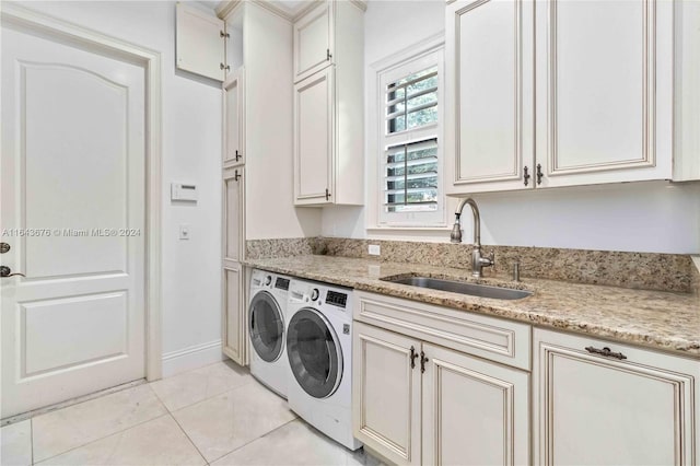 washroom featuring light tile patterned floors, cabinets, independent washer and dryer, and sink