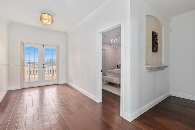 empty room with crown molding, dark wood-type flooring, and french doors