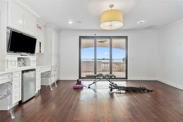 exercise room with crown molding, dark hardwood / wood-style flooring, and built in desk