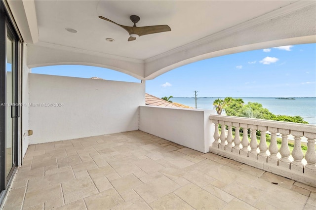 view of patio featuring a balcony, a water view, and ceiling fan