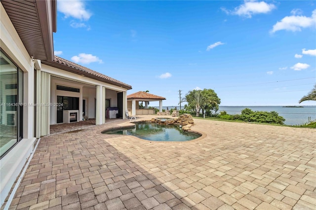 view of swimming pool with a patio area, a grill, and a water view