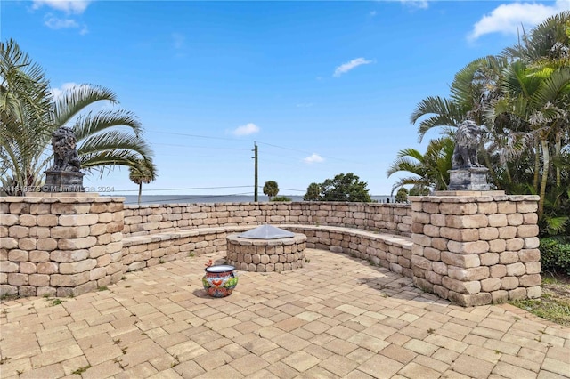 view of patio / terrace with a water view and an outdoor fire pit