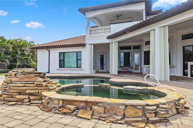 exterior space with a patio and an in ground hot tub