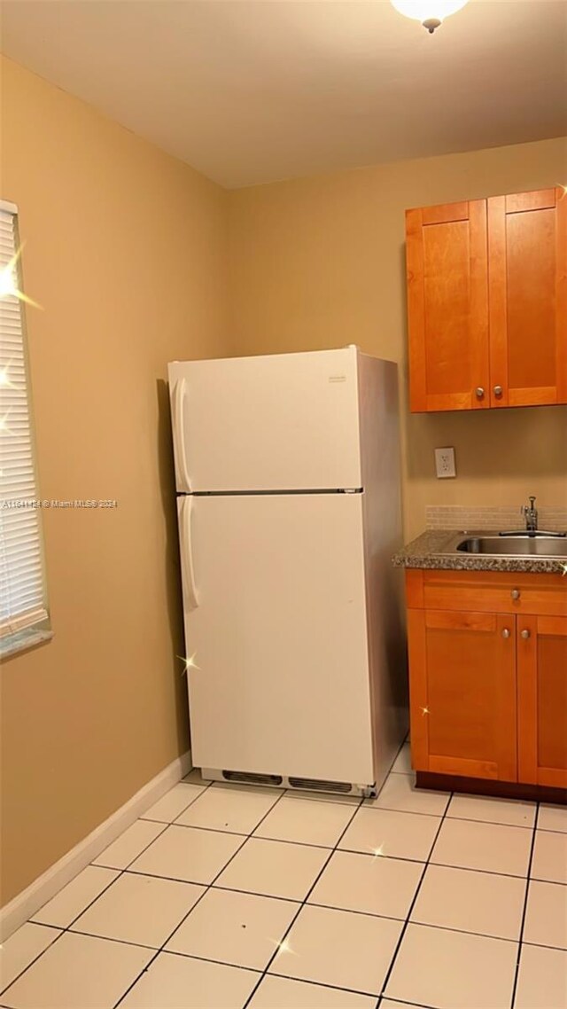 kitchen featuring sink, white refrigerator, and light tile patterned flooring