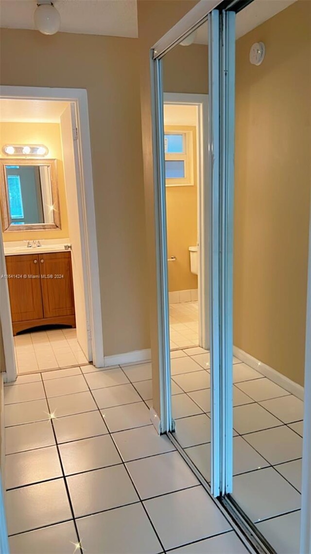 hallway with sink and light tile patterned floors