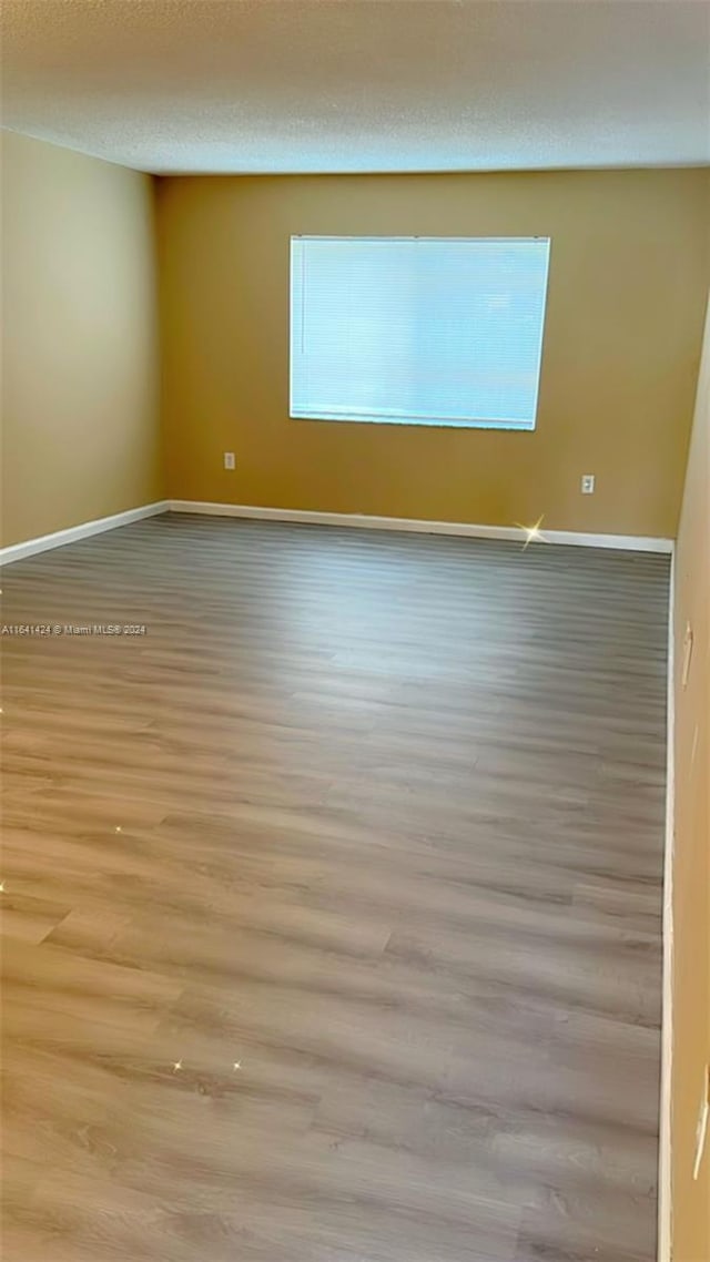 spare room featuring a textured ceiling and light wood-type flooring