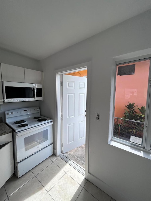 kitchen featuring light tile patterned flooring and electric stove