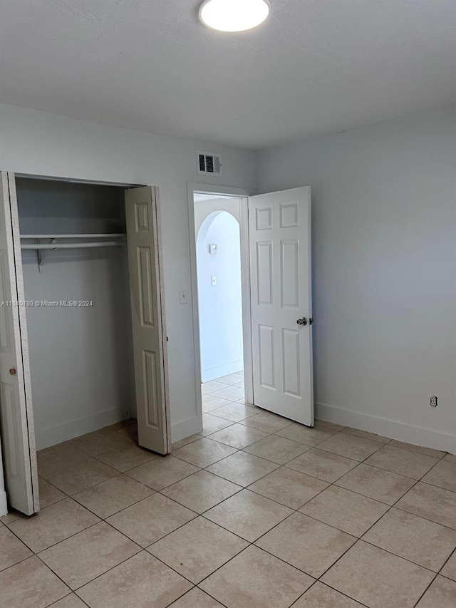 unfurnished bedroom featuring a closet and light tile patterned floors