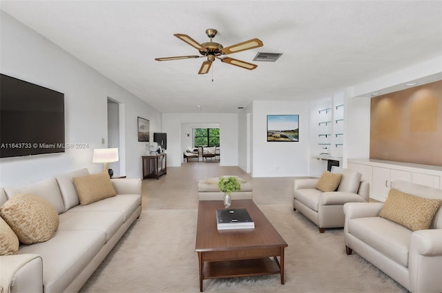 living room featuring ceiling fan and built in features