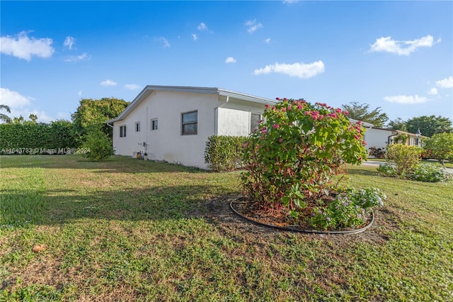 view of side of home with a yard