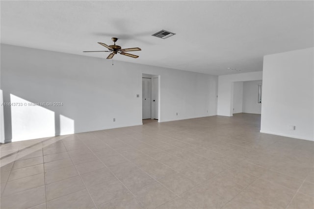 tiled spare room with ceiling fan